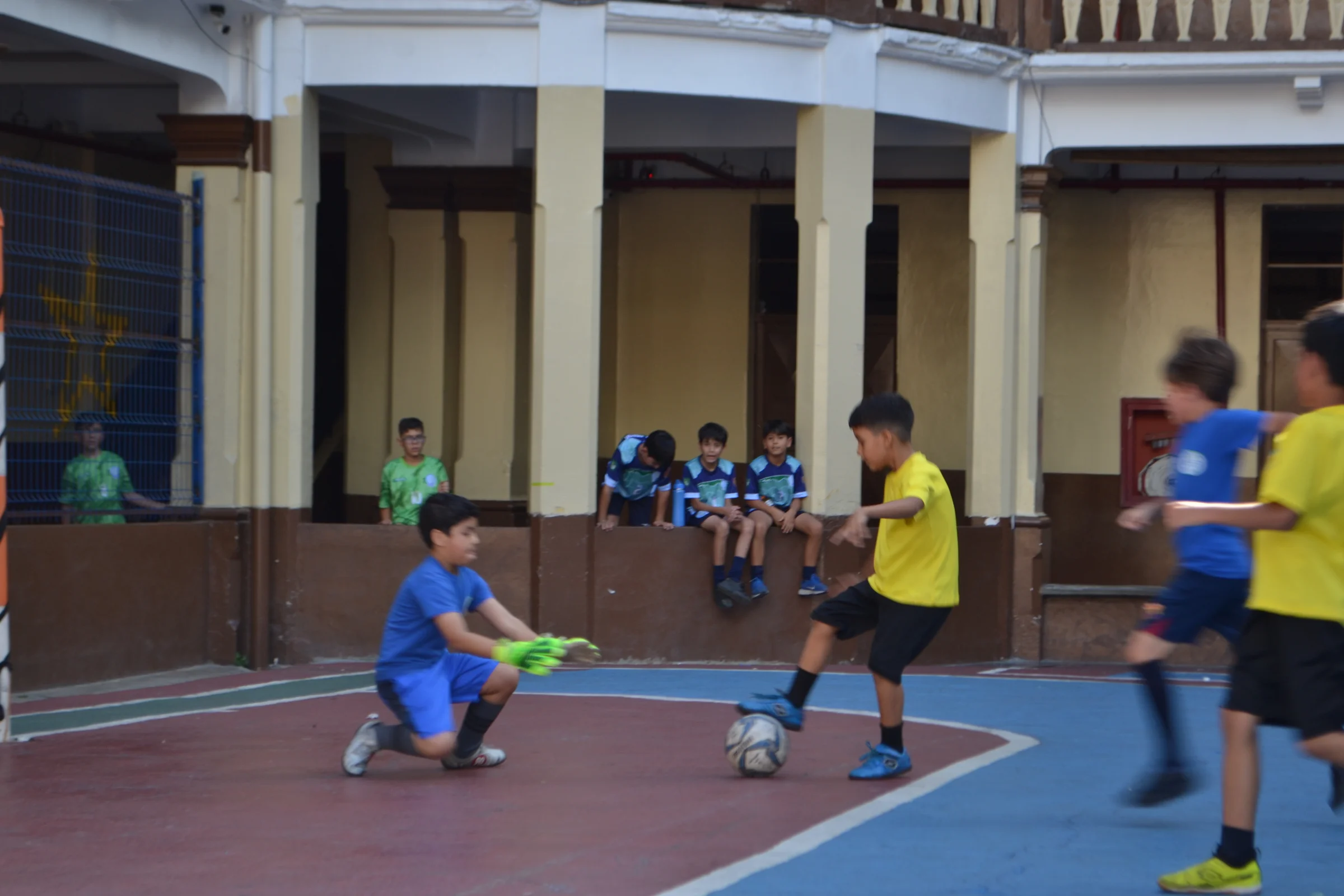 Estudiantes juegan fútbol sala en la cancha del colegio